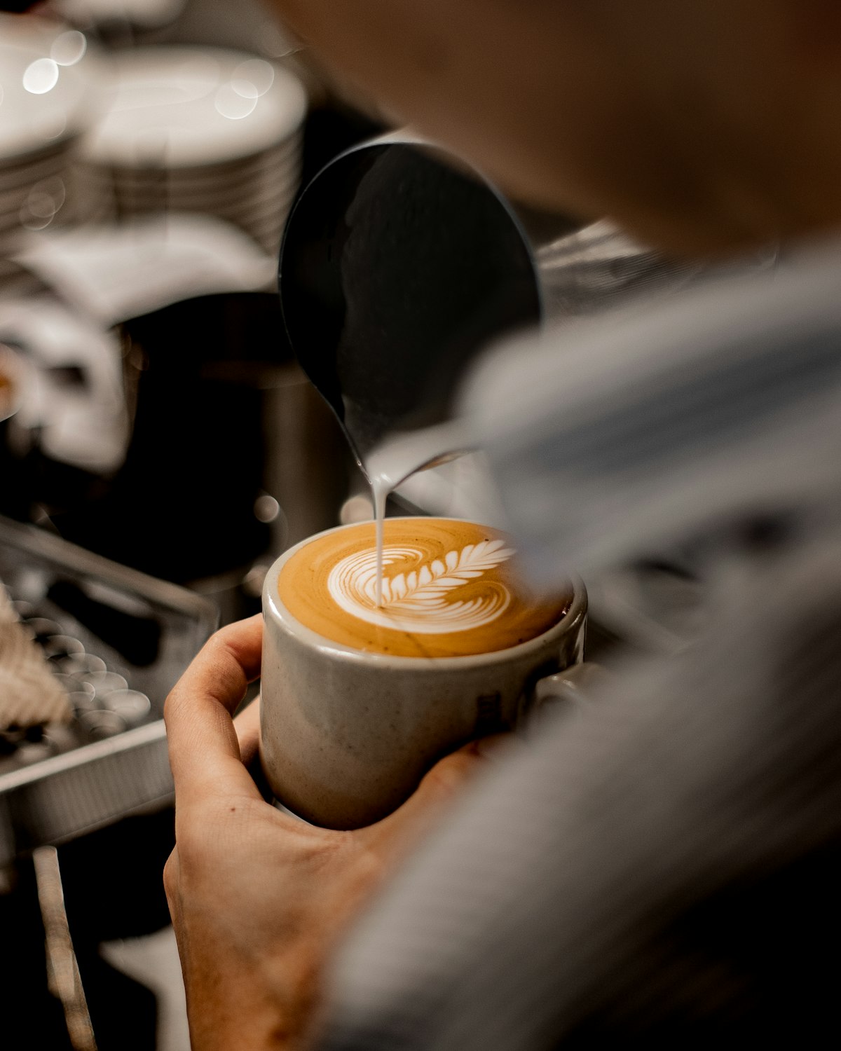 Barista pouring latte art at Stellos Coffee